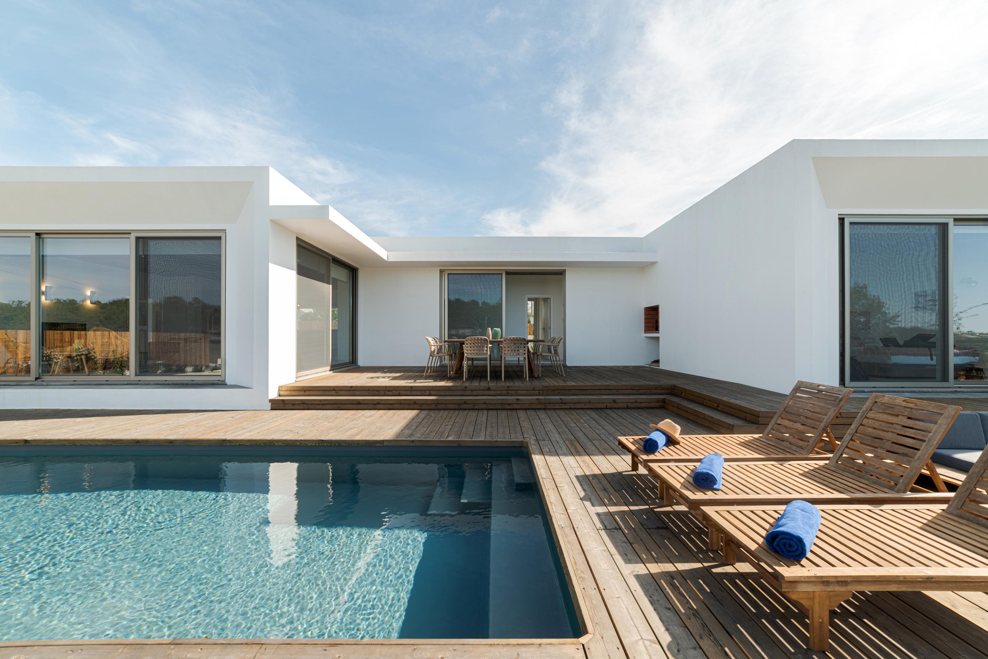 Modern white villa with a private pool and wooden sun deck