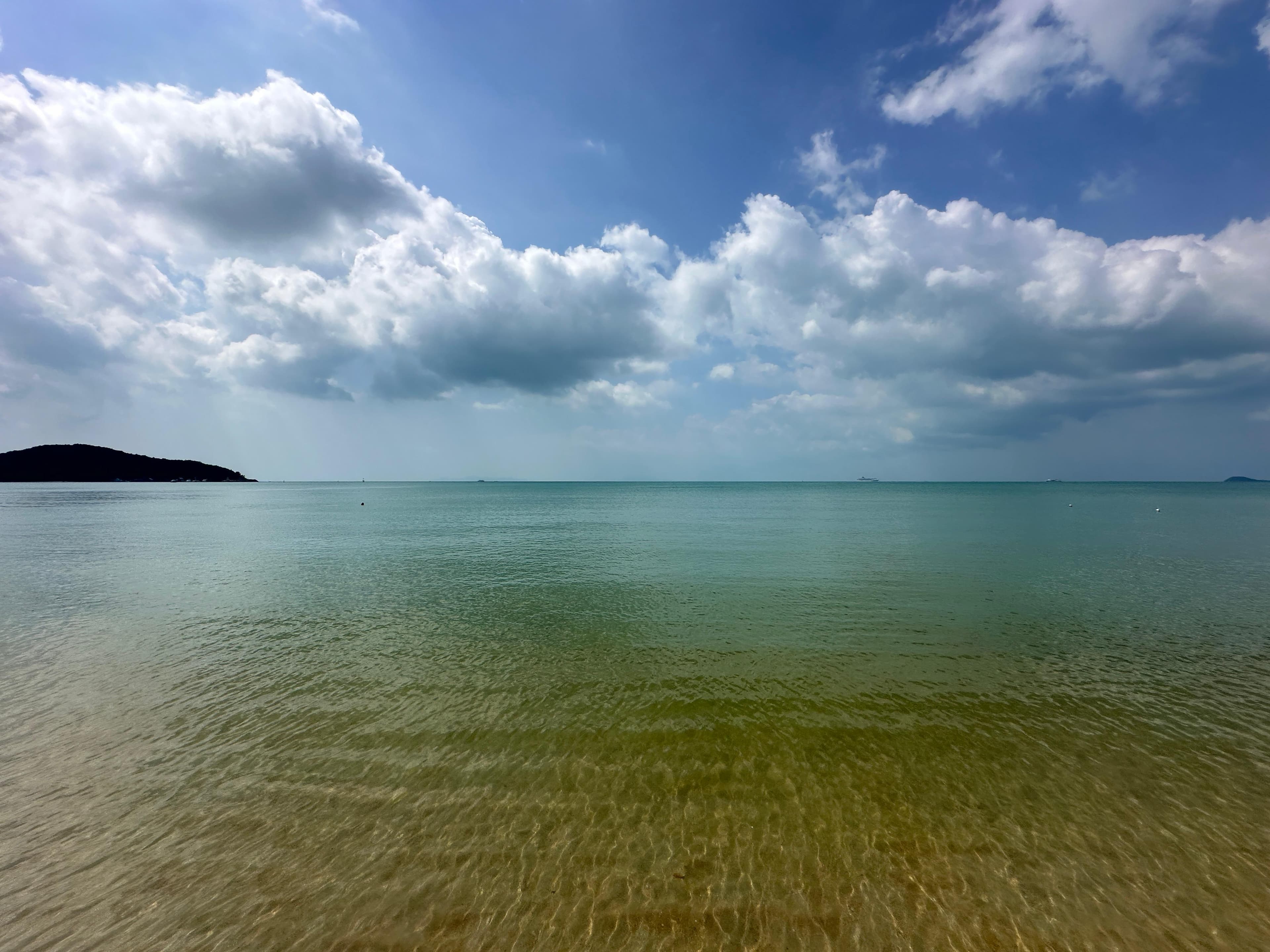 Spokojne morze u wybrzeży Koh Samui i szerokie niebo z delikatnymi chmurami