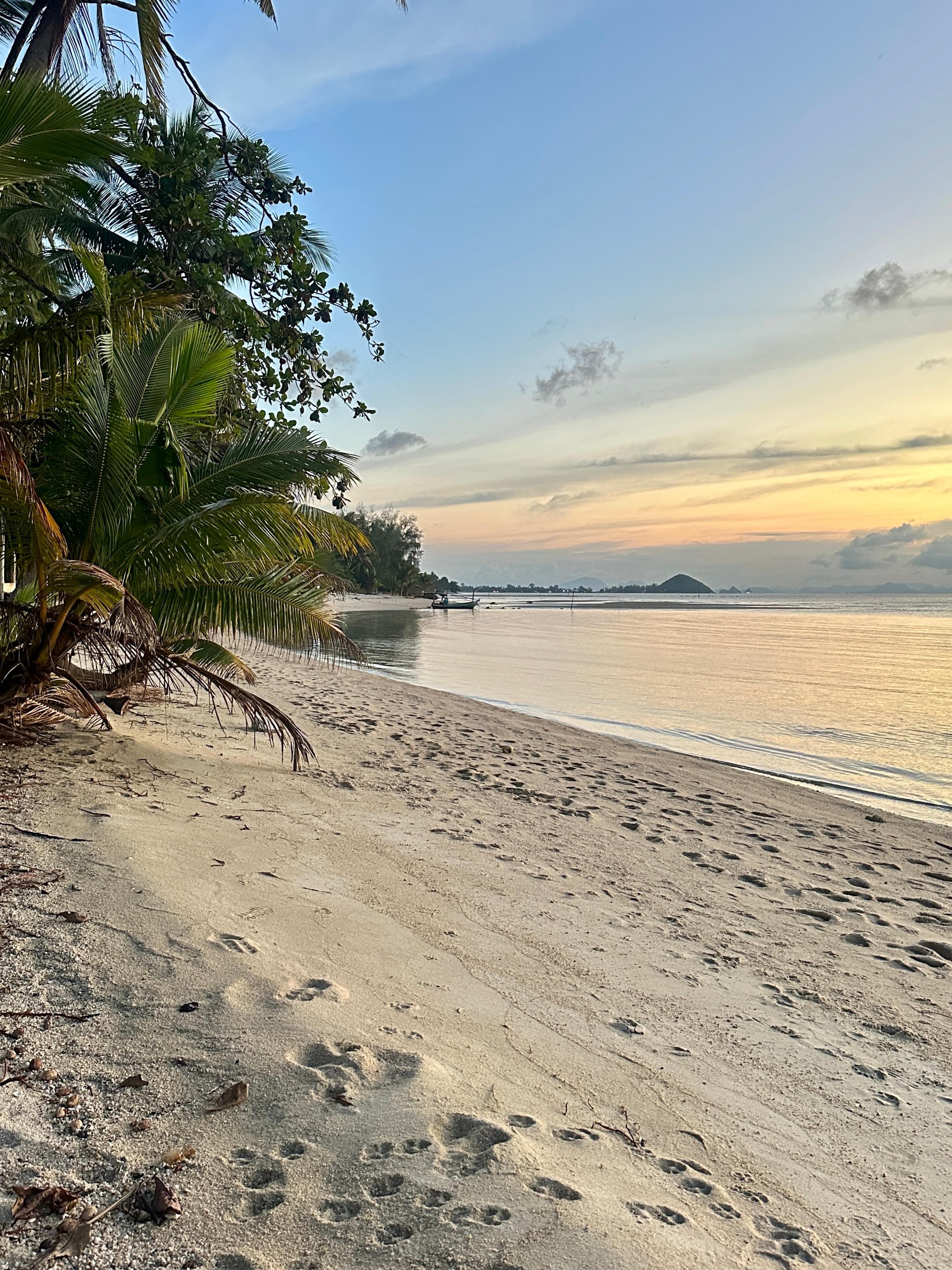 Ślady stóp na piasku na plaży Koh Samui o świcie